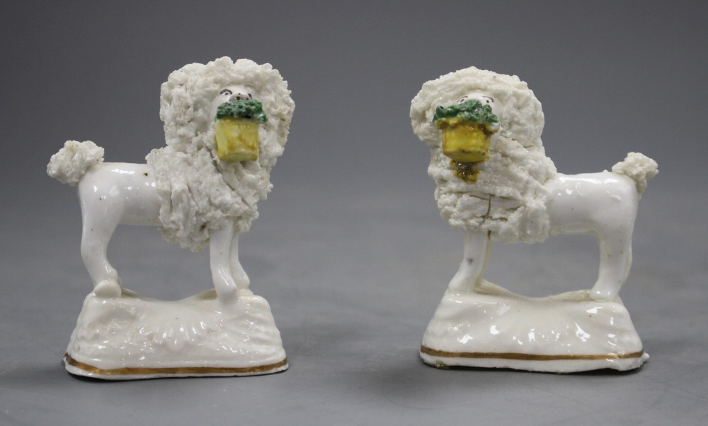 A pair of Staffordshire porcelain models of a poodle with a basket in its mouth, C.1835-50, H. 6.5cm